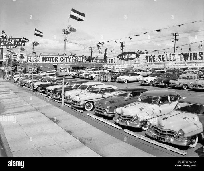 1950s-1960s-signs-and-flags-at-car-dealership-rows-of-new-cars-for-sale-by007776-cam001-hars-o...jpg