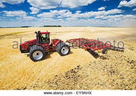 a-tractor-pulling-a-disc-harrow-works-soil-containing-barley-stubble-ey9ahx.jpg