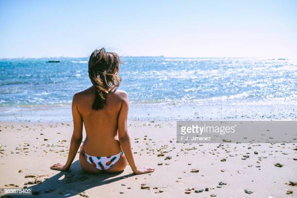 woman-in-toples-sitting-on-the-beach-view-from-behind-picture-id953875402?s=612x612.jpg