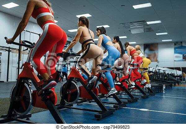 women-doing-exercise-on-stationary-bike-stock-photo_csp79499823.jpg