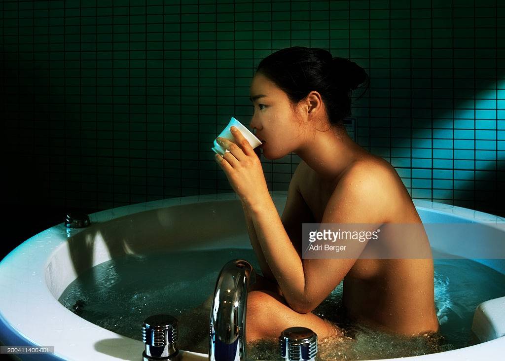 young-woman-sitting-in-hot-tub-drinking-tea-side-view-picture-id200411406-001.jpg